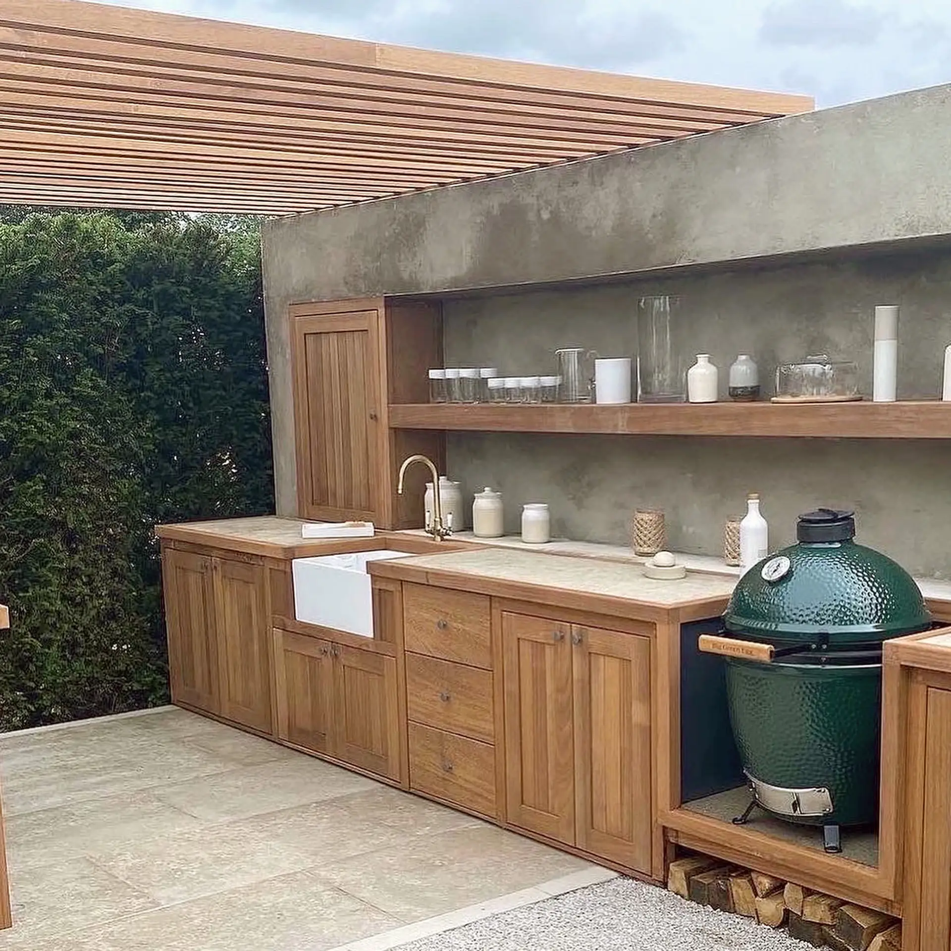 A bespoke wooden pergola frame above an outdoor kitchen made by EMH Joinery, Norfolk.